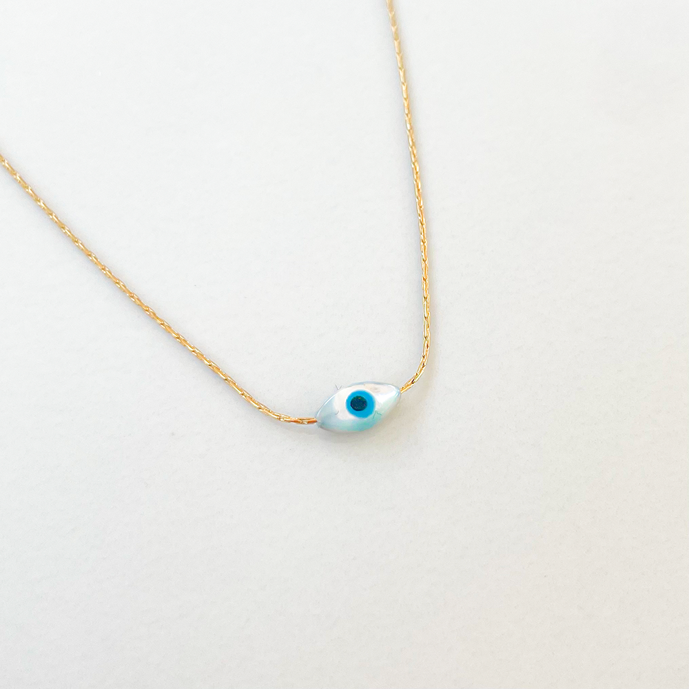 un collier en acier inoxydable brille avec élégance, mettant en valeur un pendentif oeil qui attire immédiatement le regard. La finesse des détails du pendentif crée une aura envoûtante, semblant observer mystérieusement son environnement. L'acier inoxydable ajoute une touche moderne et sophistiquée, faisant de ce collier un accessoire à la fois audacieux et raffiné.