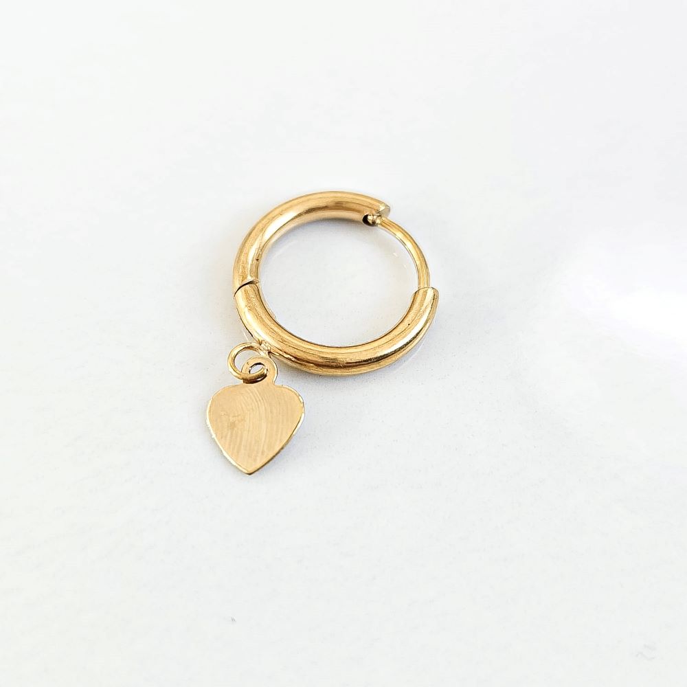 La photo représente une boucle d'oreille en acier inoxydable muni d'un pendentif cœur doré