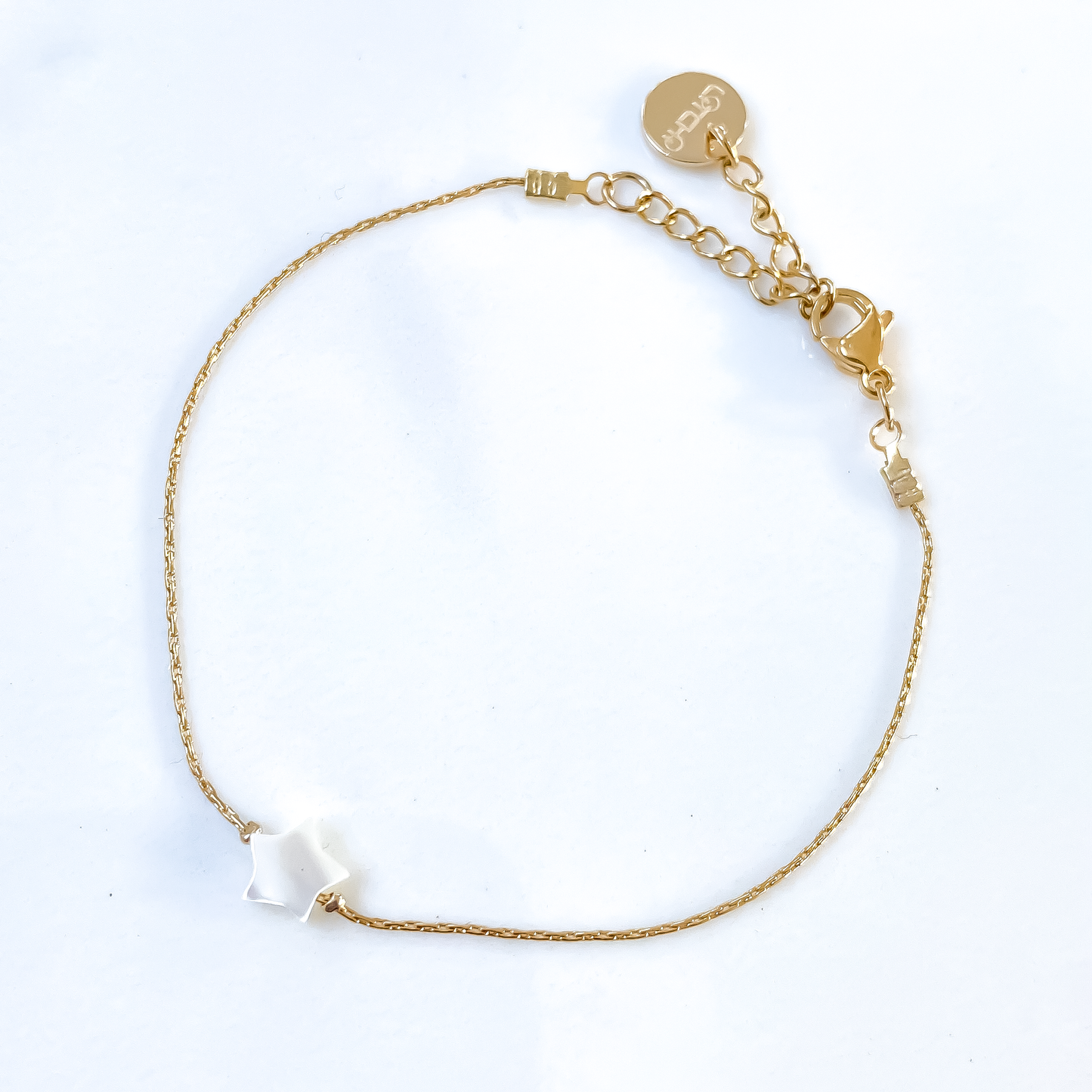 Un bracelet en acier inoxydable, robuste et élégant, entourant délicatement le poignet. Son pendentif en étoile en nacre, dégageant une aura de délicatesse et d'éclat naturel, captivant le regard par sa finesse. Une fusion harmonieuse entre la force de l'acier et la douceur de la nacre, incarnant un style intemporel et raffiné.