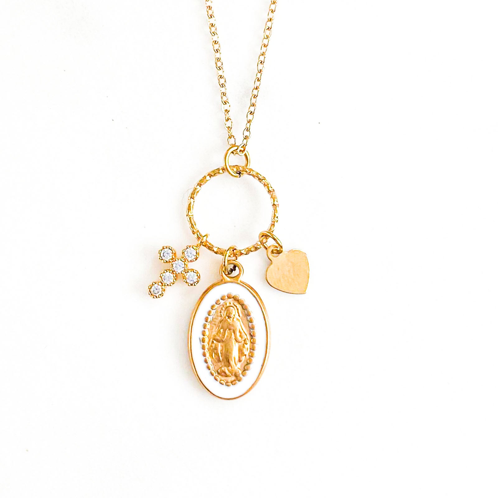 Une photo captivante présente le "Collier Grappe Marie" : blanc immaculé, orné d'un pendentif cœur doré, d'une croix strassée et d'une vierge délicate. Son éclat saisissant et sa symbolique religieuse offrent une touche d'élégance et de spiritualité, idéale pour compléter toute tenue avec grâce et style.