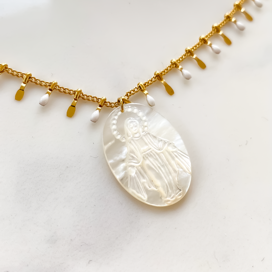 Le collier long Mary Vierge blanche est une pièce d'une élégance intemporelle. Avec sa chaîne délicate et son pendentif représentant la Vierge Marie, il évoque une aura de pureté et de grâce. Sa couleur blanche lumineuse ajoute une touche de douceur à n'importe quelle tenue. Porté avec un simple t-shirt ou une robe élégante, ce collier ajoute une touche de sophistication discrète. Parfait pour ajouter une note céleste à votre style quotidien