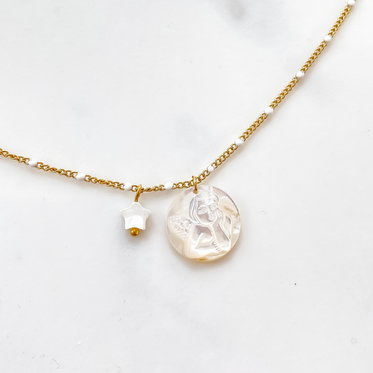 Une composition éblouissante se dévoile : un collier en acier inoxydable captivant, sublimé par un pendentif en nacre blanche délicatement ciselé, représentant l'ange de la Vierge Marie. L'éclat argenté de l'acier contraste harmonieusement avec la douceur nacrée du pendentif, créant une symbiose entre force et grâce, foi et élégance. C'est une pièce qui semble porter en elle une aura de protection et de spiritualité, captivant le regard et l'âme.
