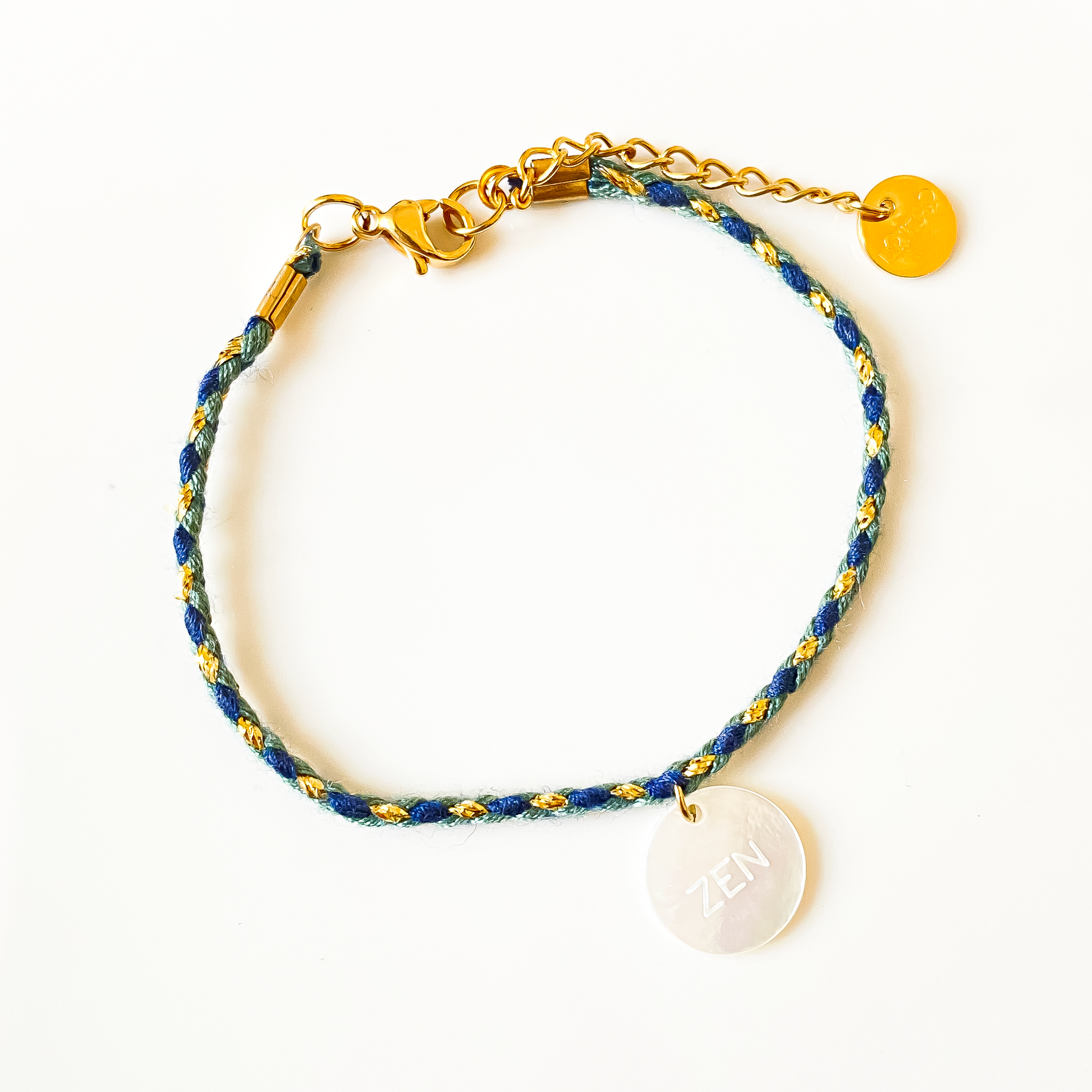 Sur la photo, un bracelet en cordon bleu captivant, orné d'un délicat pendentif en nacre. Le mot "zen" est élégamment inscrit sur le pendentif, évoquant un sentiment de calme et de sérénité. Un accessoire parfait pour ajouter une touche de tranquillité à votre style quotidien.