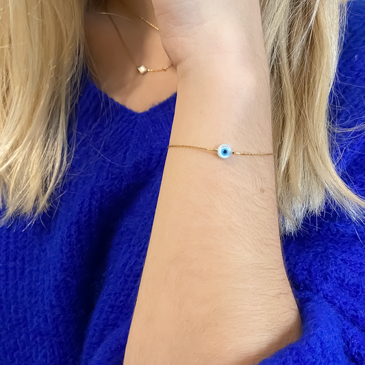 Un bracelet en acier inoxydable robuste et élégant, agrémenté d'un pendentif en forme d'œil, évoquant la vigilance et la protection.